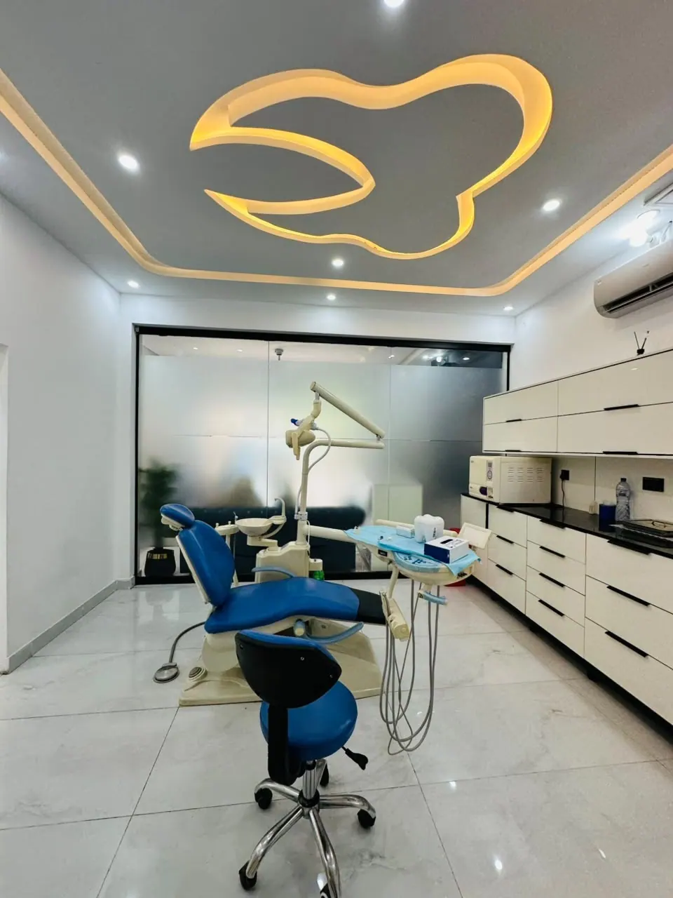 Modern dental operatory room with illuminated tooth ceiling light at Narowal Dental Clinic